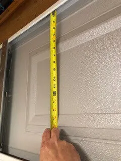 Measure the garage door panel including the space behind the lip.