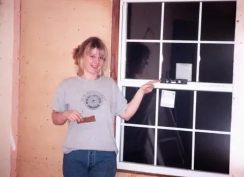 My wife showing off her leveled storm window install - increased energy efficiency!