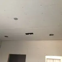 Aligning drywall corners properly.
