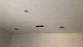 Aligning drywall corners properly.